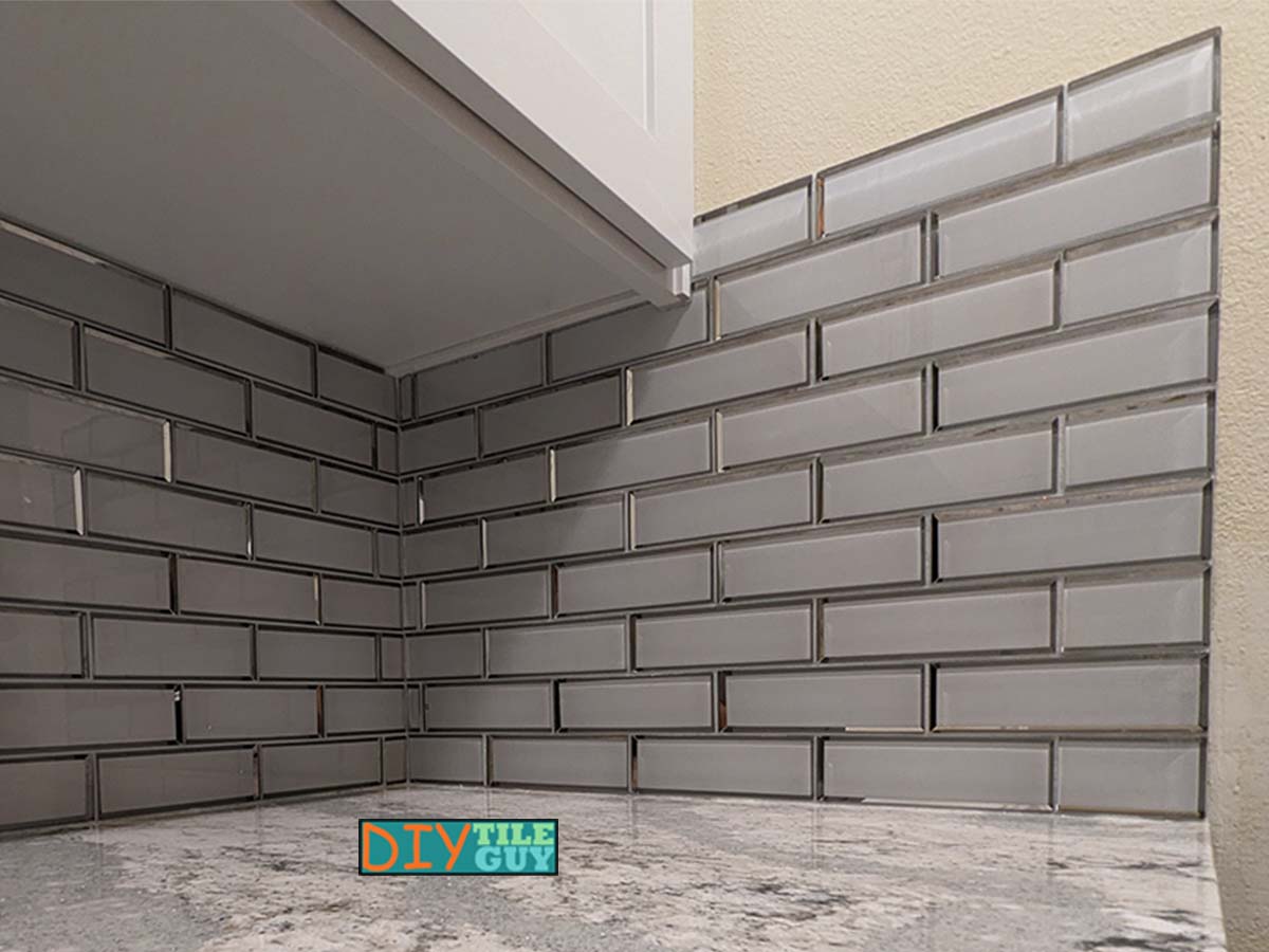 glass tile backsplash is an additional row higher past the upper cabinets