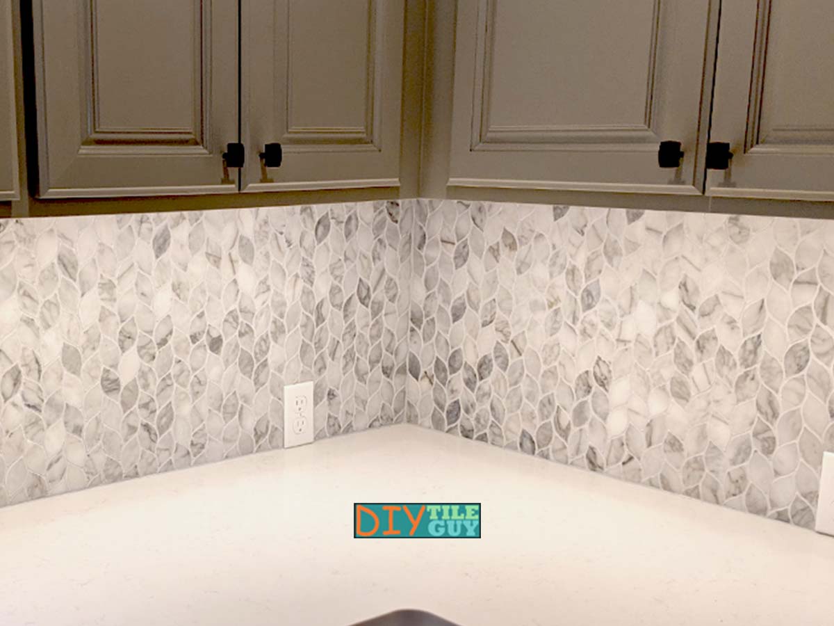 Carrara marble leaflet tile installed as a full height kitchen backsplash