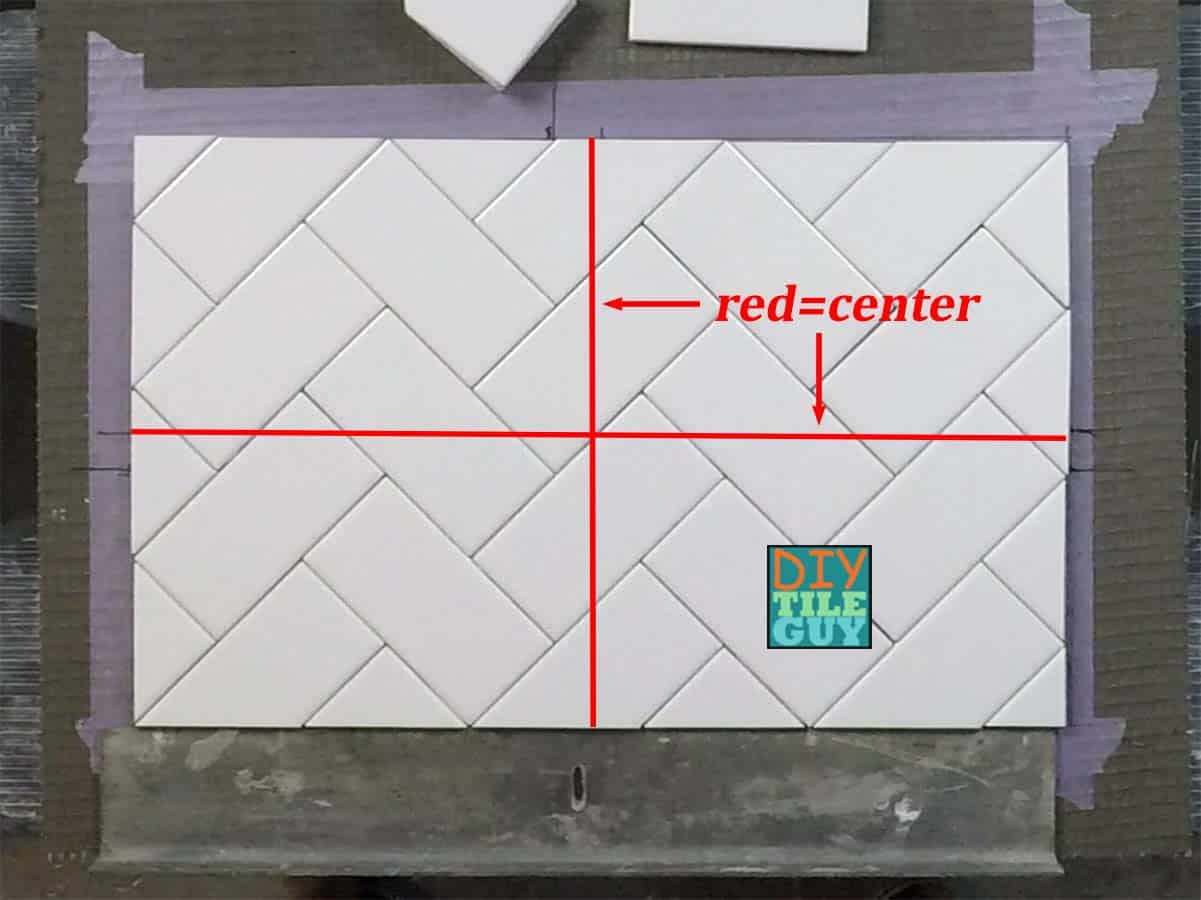 two red lines, one vertical and one horizontal, showing the center of the herringbone pattern with 3x6 subway tile